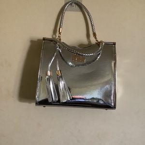 Silver faux leather handbag by Bebe Los Angeles. 12” length X 11” high.